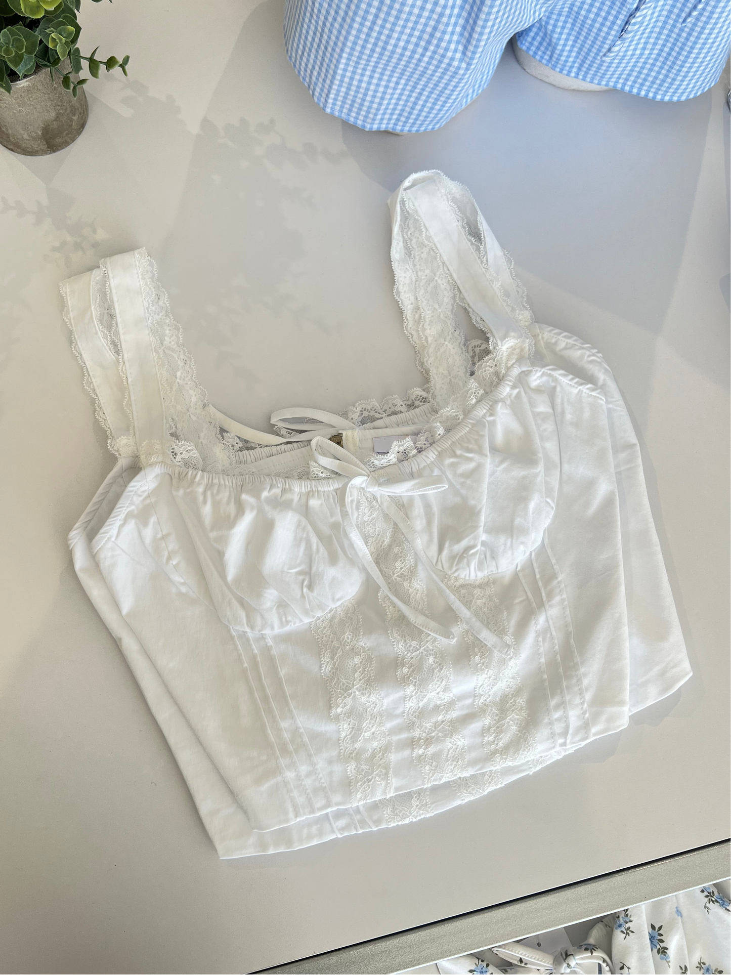 White lace top on a white surface with a blurred background