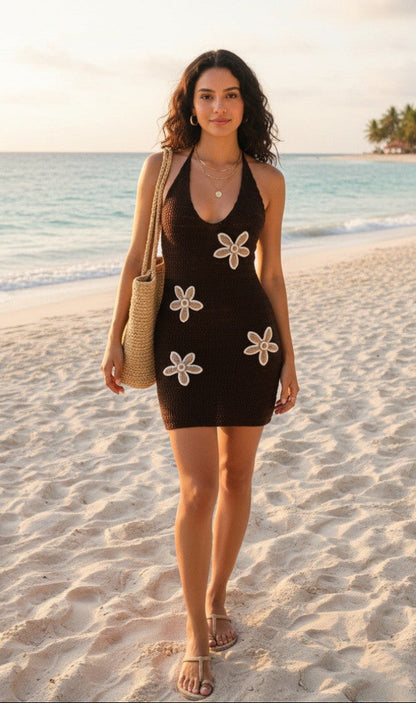 Woman in a brown dress with floral patterns on a beach