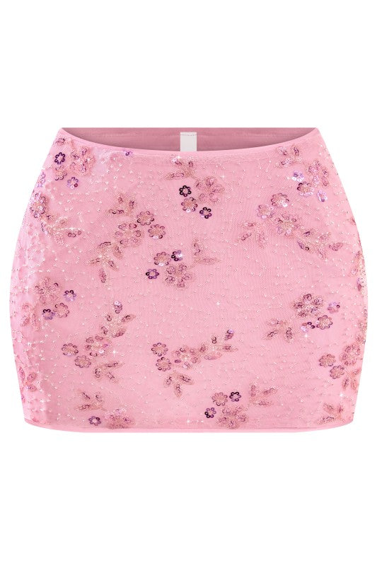 Pink floral sequin skirt on a white background. This pink floral sequin mini skirt is the perfect party skirt for birthdays, date nights, vacations, and girls’ night outfits.