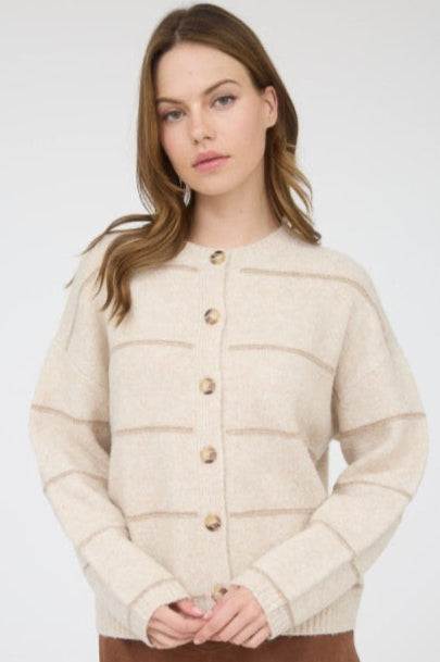 Woman wearing a beige cardigan over a brown skirt on a white background