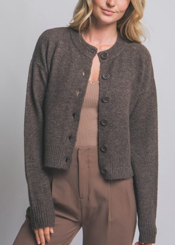 brown knitted cardigan over a beige top